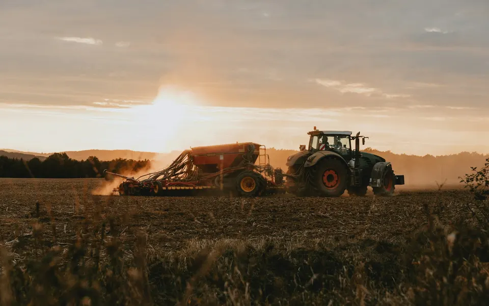A seeder working an autumn field in the Czech Republic at low evening light.